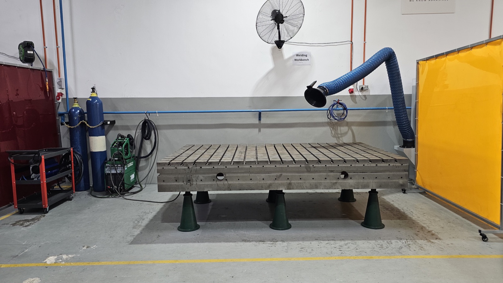 Slotted welding workbench with extraction equipment and a protective screen